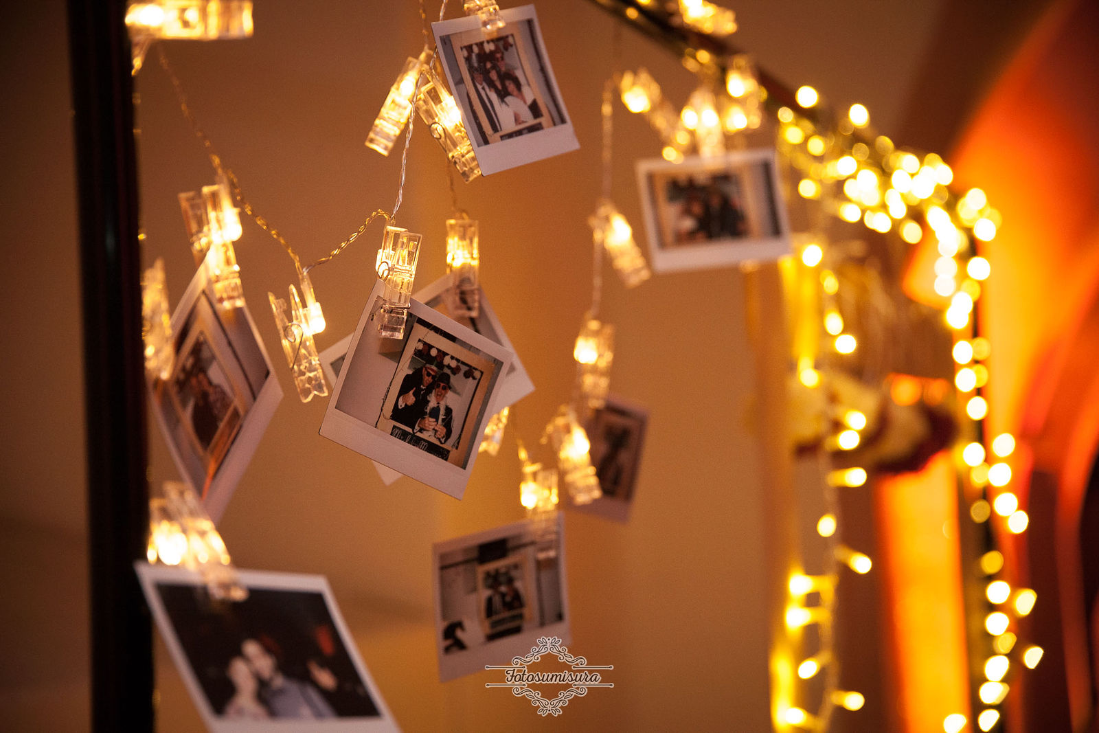Fotografie istantanee appese fra piccole luci durante una festa